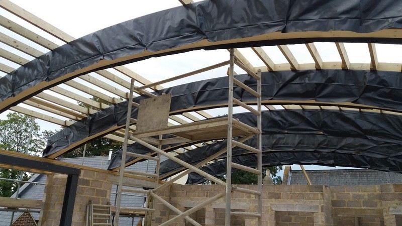 Photo inside the New Hall during its building, looking up to the roof in the process of construction